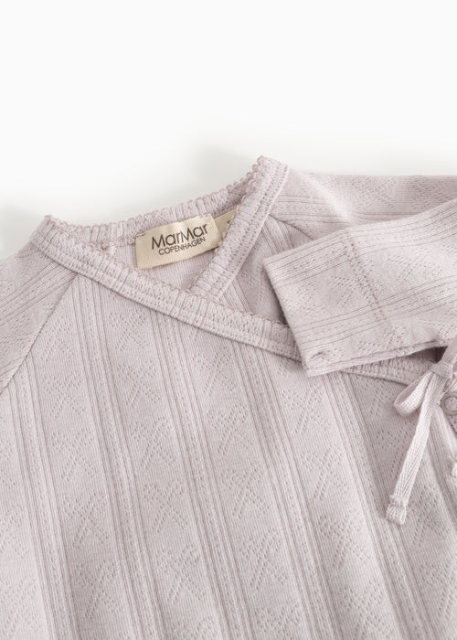 Boxpakje Rula Violet Dust – Modal & organic cotton – MarMar Copenhagen: detail of the neckline and wrap closure of the romper.