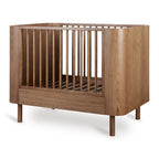 Yume Bed 110 × 70 cm – Mitwachsendes Bett aus Eschenholz – Quax: Babybett schräg von vorne.