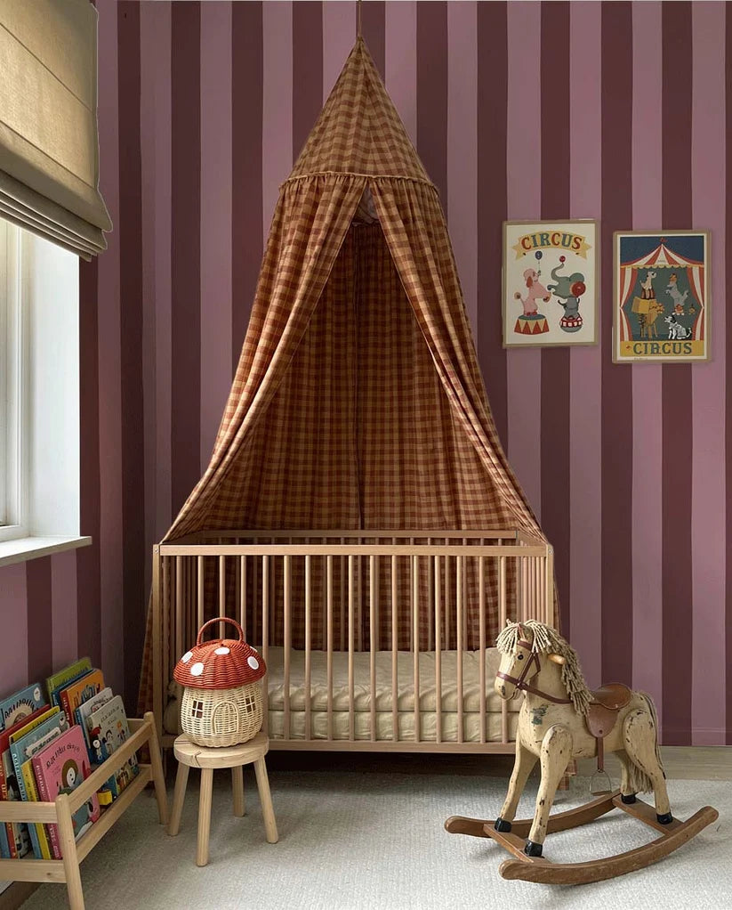 Brede Strepen Bordeaux Roze – Atelier Chien: wallpaper in a nursery with a bassinet and canopy.