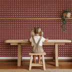 Carreaux Quilt Bordeaux – Atelier Chien : papier peint derrière un enfant à une table en bois.