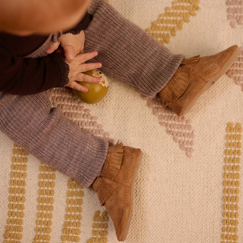 Moccasin Suede Slippers – Leren babyslofjes met suède antislipzool – MELTON: Babyschuhe an den Füßen eines Kindes, aus der Nähe.