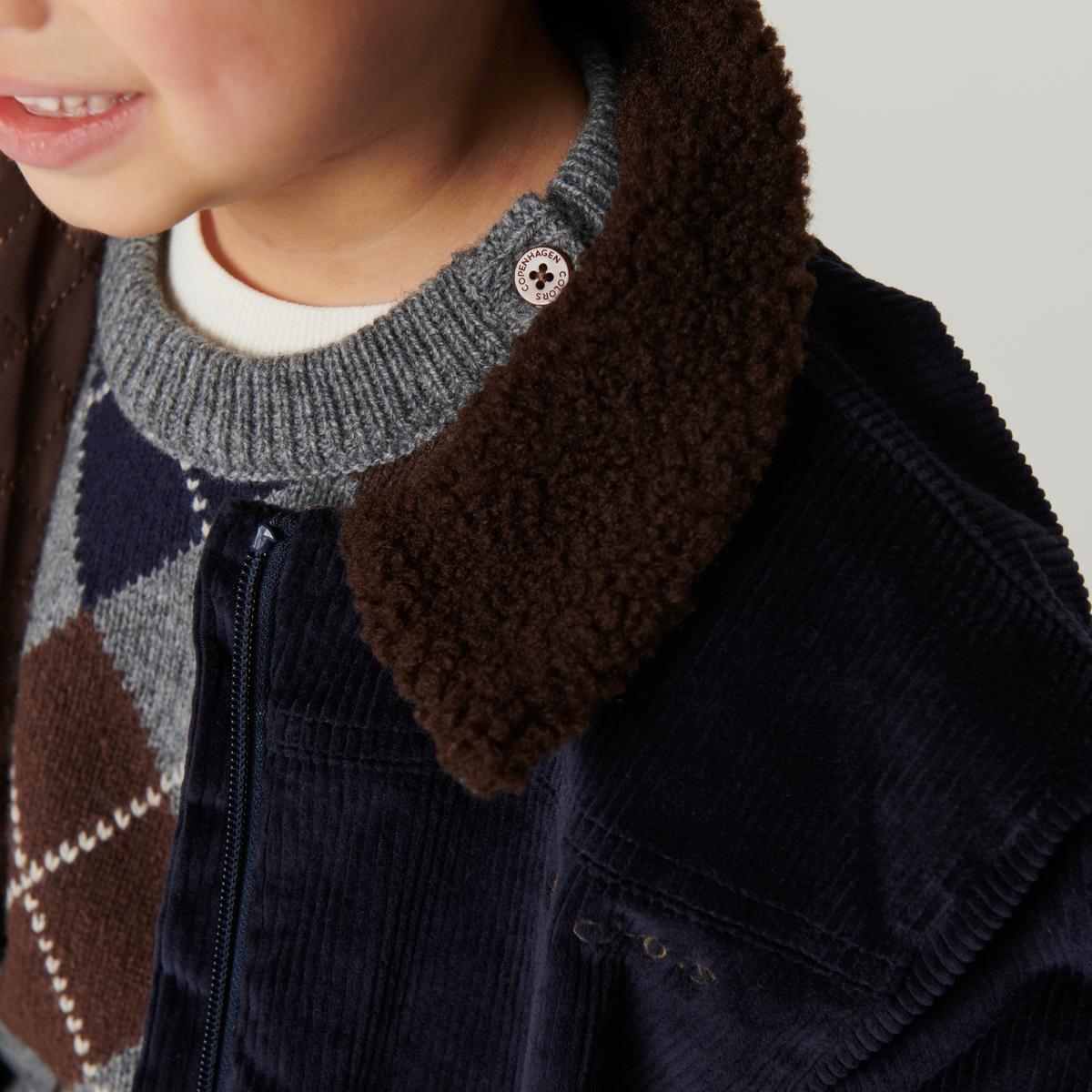 Pull en maille à carreaux - Pull à losanges - Laine d'agneau - Couleurs de Copenhague - Gros plan sur un enfant portant un manteau