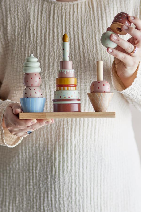 Celebrate Activity Toy – Bloomingville MINI: Detail einer Hand, die ein Teil auf einen Stapel setzt.